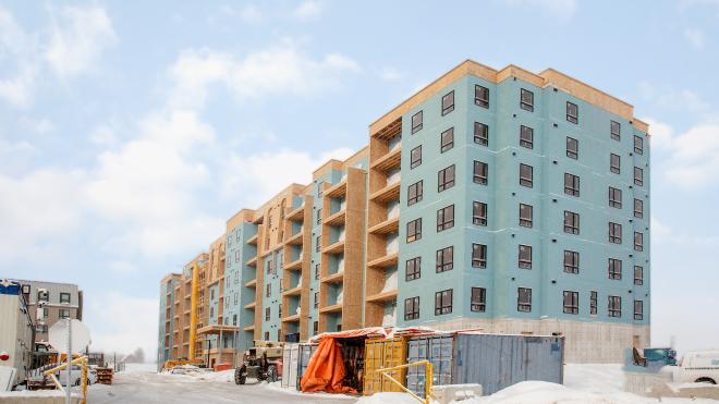 Building development under construction. There is heavy machinery parked near the construction site.