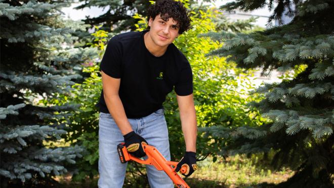 Young man holding lawn care equipment