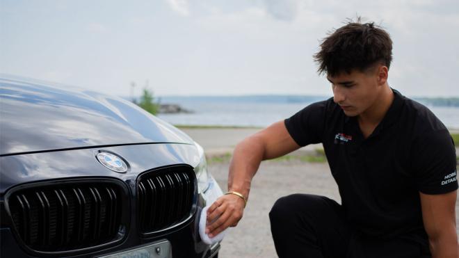 Young man waxing a car