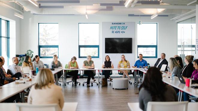 Group of business people sitting around a table at the Sandbox Centre