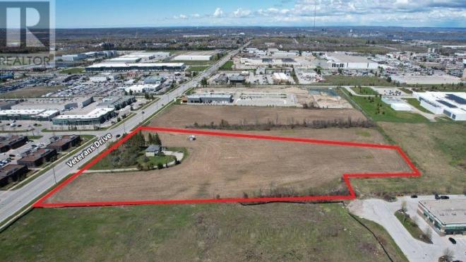 Aerial view of a large field near an industrial area.