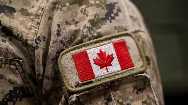 Canadian flag patch on camouflage military uniform.