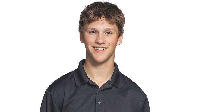 Teen wearing a dark polo shirt, smiling against a white background.
