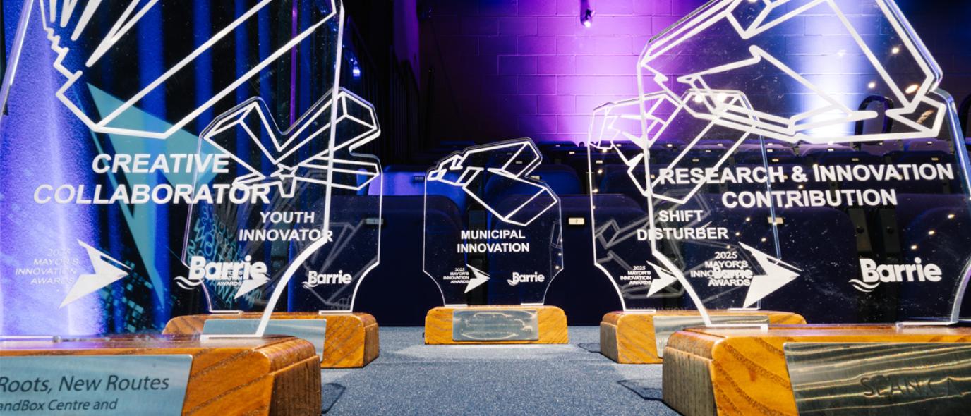 Glass trophies on wooden bases under purple and blue lights.