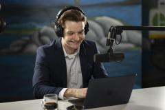 Harrison Cowden working at laptop with mic and headphones