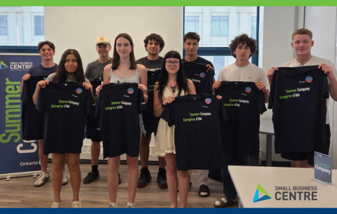 Group of teenagers participating in the 2025 Summer Company program, holding up Summer Company t-shirts