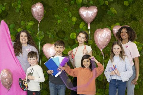 Sabrina and some of her students posing in a group with craft and sewing supplies