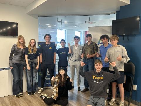 Group of smiling teenagers posing indoors.