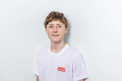 Teen in white shirt standing against a plain white background.