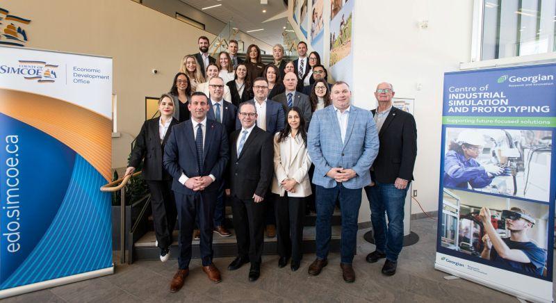 A group of people standing between a County of Simcoe banner and a Georgian College banner.